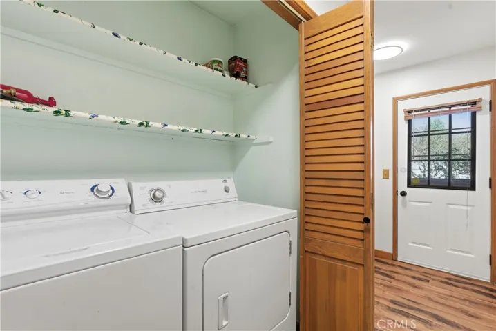 Laundry area with shelves, washer and dryer (they are included), wood doors that can be closed when not in use