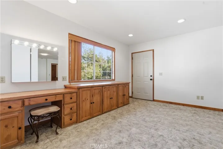 Lighted vanity area and wood cabinets in Primary Bedroom.