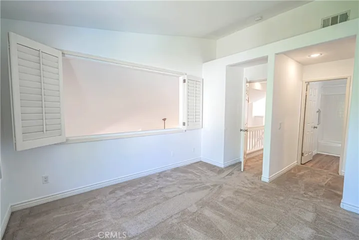 Upstairs guest bedroom with wood shutters and view of Living Room.