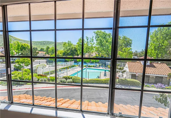 View of mountain, pool and tennis court from primary bedroom.