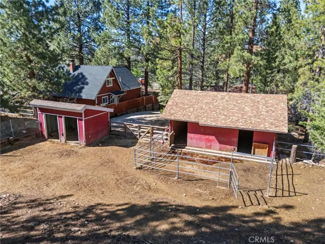 This is a picture from the back of the property showing the open air barn as well as the large barn and corrals