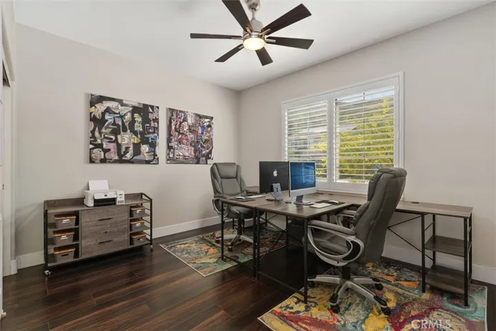 Downstairs bedroom with ceiling fan currently being used as an office