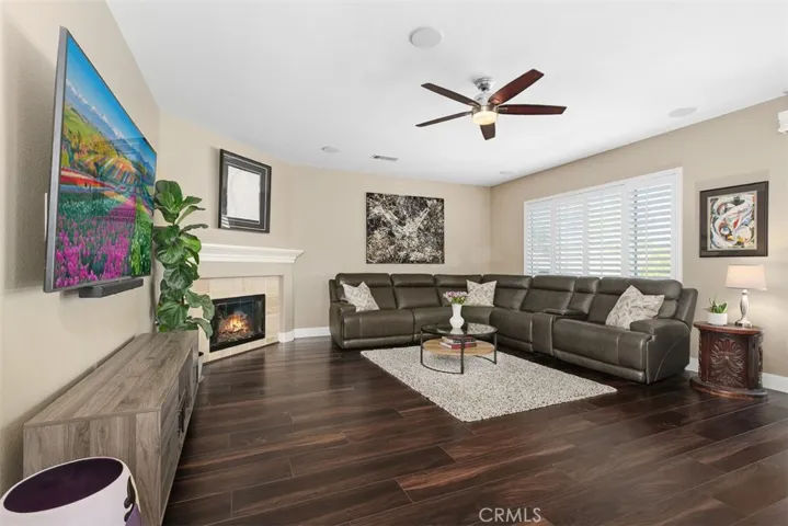 Family room with ceiling fan, fireplace, plantation shutters, LVP flooring  & ceiling speakers,