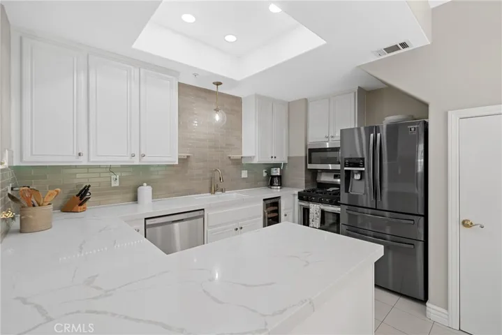 White cabinets, quartz countertops, and subway tile backsplash.