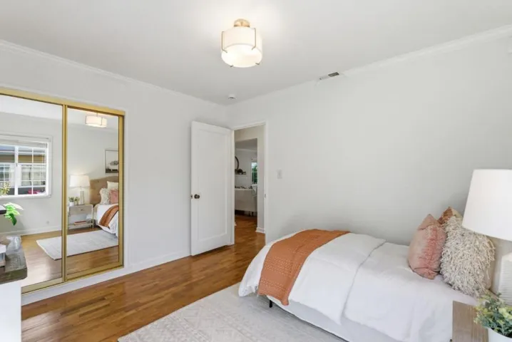 Second bedroom with windows looking out to patio and lush backyard