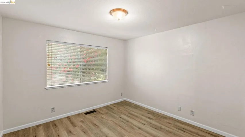Unfurnished room with light wood finished floors and baseboards