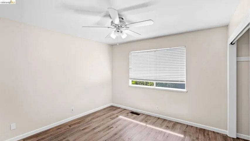 Unfurnished bedroom featuring a closet, light wood-style flooring, and a ceiling fan