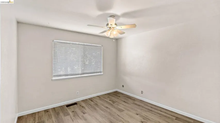 Spare room with light wood finished floors and ceiling fan