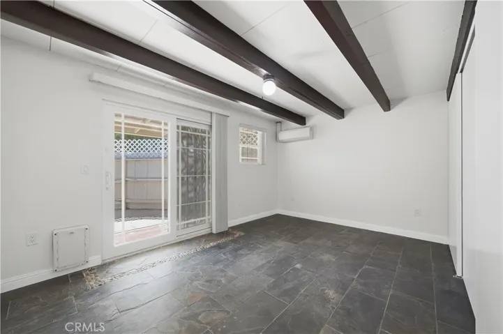 Bedroom 2 w slate flooring, all new paint and dual pane sliding doors leading to the enclosed back patio area.