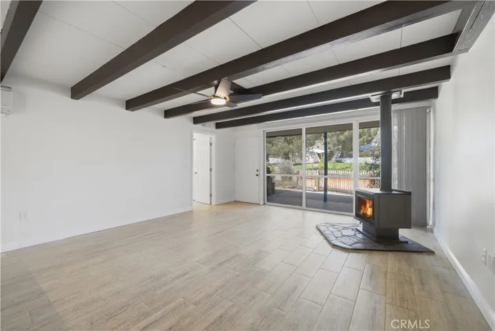 Alternate view of living room w front yard and community green belt visible thru the floor to ceiling windows