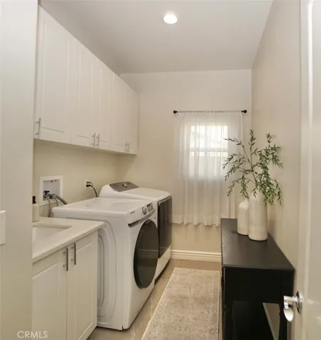 FIRST FLOOR LAUNDRY ROOM WITH A SINK AND UPPER CABINETS
