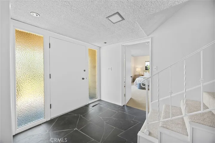 Slate floors and a double-door entry offer a subtle nod to the home’s mid-century modern roots.