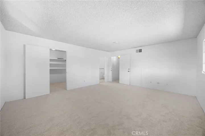 Bright and spacious upstairs ensuite bedroom with a walk-in closet for ample storage.