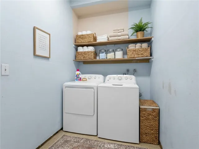 Indoor Laundry Area With Storage Shelving And Washer And Dryer - Digitally Staged