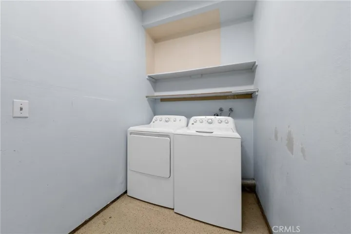 Indoor Laundry Area With Storage Shelving And Washer And Dryer