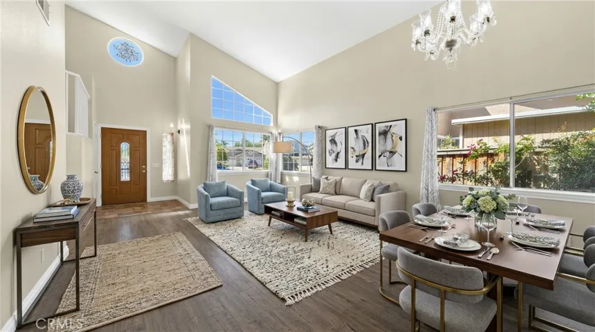 Bright Living Room With Vaulted Ceilings, Large Windows, And Wood-Look Flooring - Digitally Staged