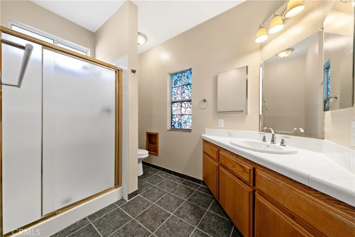 Downstairs Primary Bathroom With Dual Sinks, Large Vanity, And Walk-In Shower