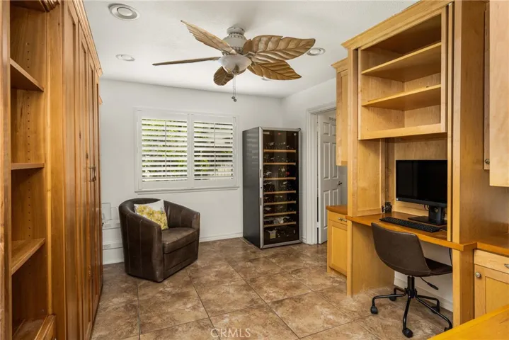 Graced with a stylish ceiling fan and lots of built-in cabinetry, this flexible bedroom can also double as an extra office space.