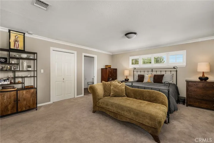 This view of the primary bedroom shows the entry into the private ensuite bathroom. and additional closet storage.