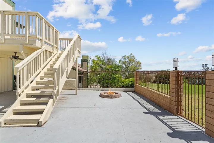 Outdoor staircase leads to the elevated deck while the patio below offers an open layout with hillside and neighborhood outlooks.