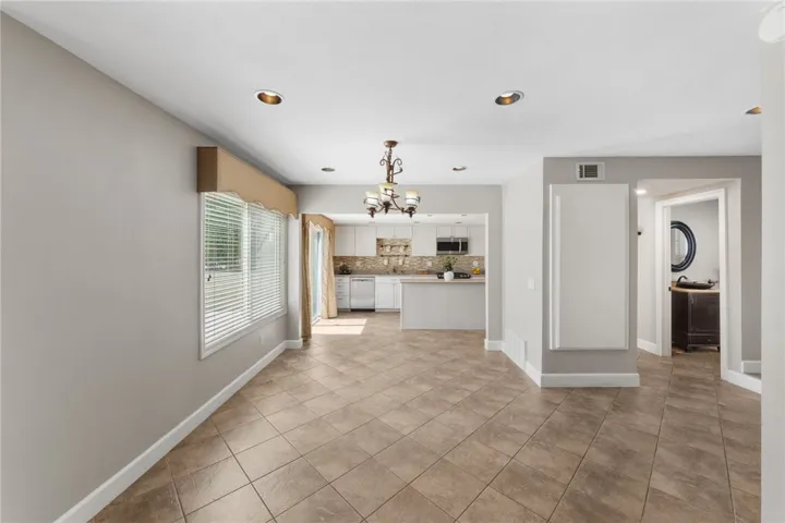 Light-filled dining area offers an open connection to the kitchen, with tile flooring and a spacious layout for everyday meals or entertaining.