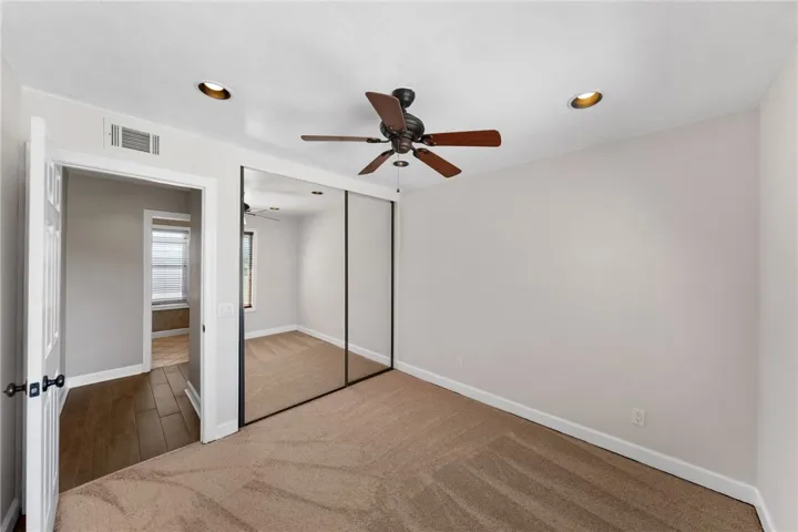 Additional bedroom offers mirrored closet doors, neutral finishes, and a functional layout.