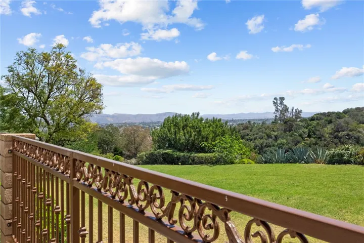 Backyard patio opens to a broad greenbelt-style setting with sweeping views of surrounding hills and mature landscape.