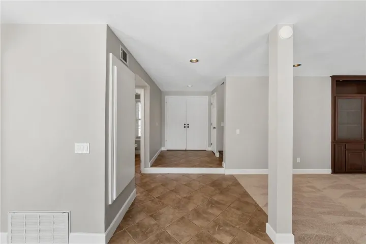 Entry hall leads into the main living spaces with tile flooring, neutral finishes, and a bright, open feel.