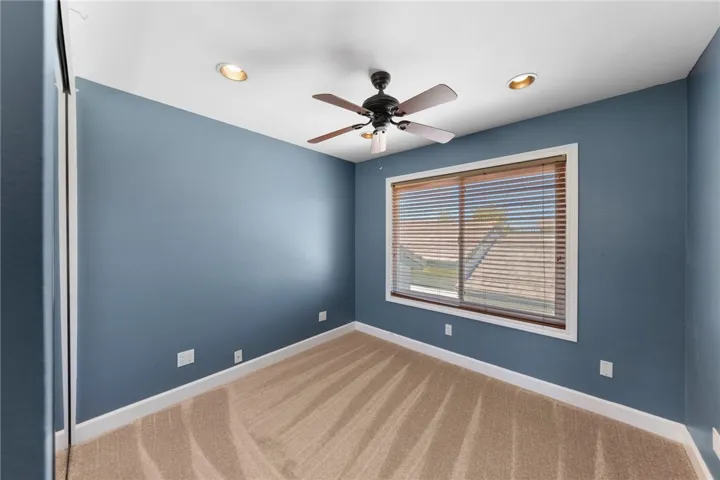 Well-sized bedroom features updated flooring, recessed lighting, and a window overlooking the neighborhood.