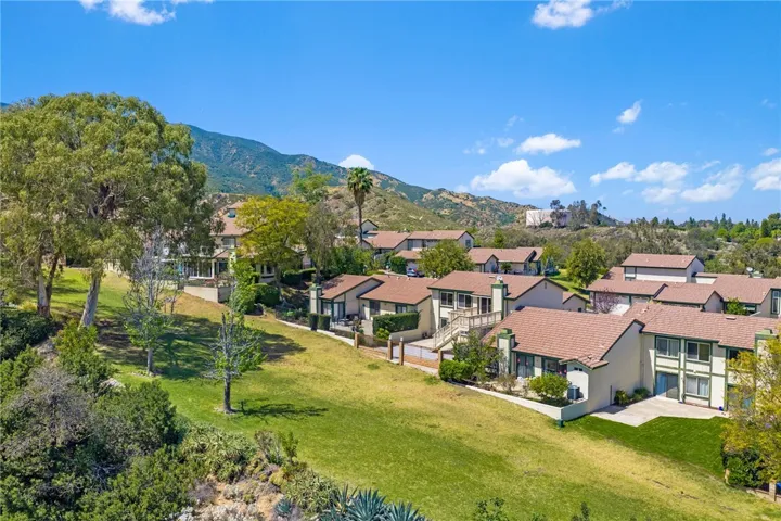 Community aerial highlights the home’s scenic location with nearby open space, mature trees, and mountain views.