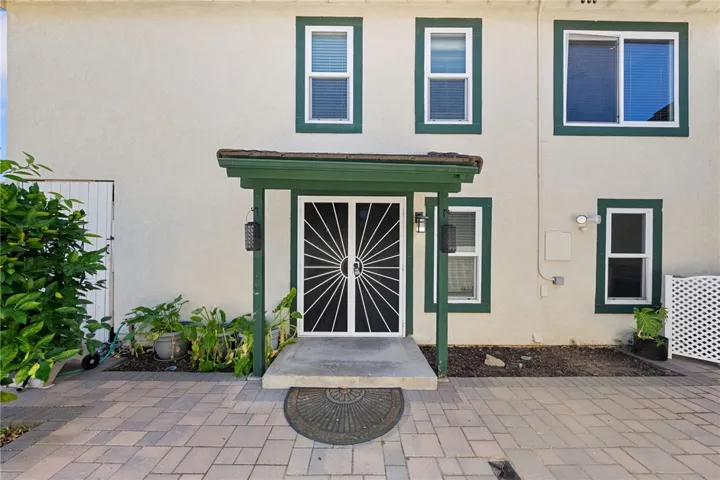 Private front courtyard entry features paver hardscape, covered access, and a welcoming sense of arrival.