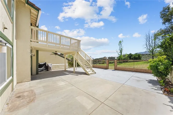Spacious rear patio offers plenty of room for outdoor seating and entertaining beneath the upper deck.