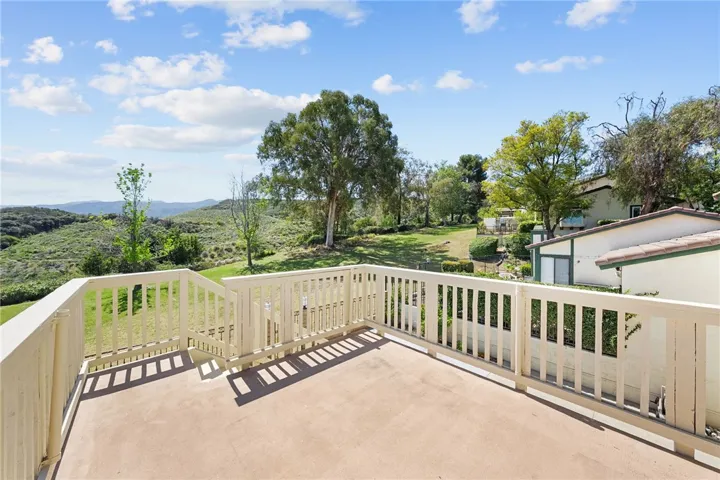Elevated deck enjoys peaceful views of the surrounding greenbelt, mature trees, and rolling hills.