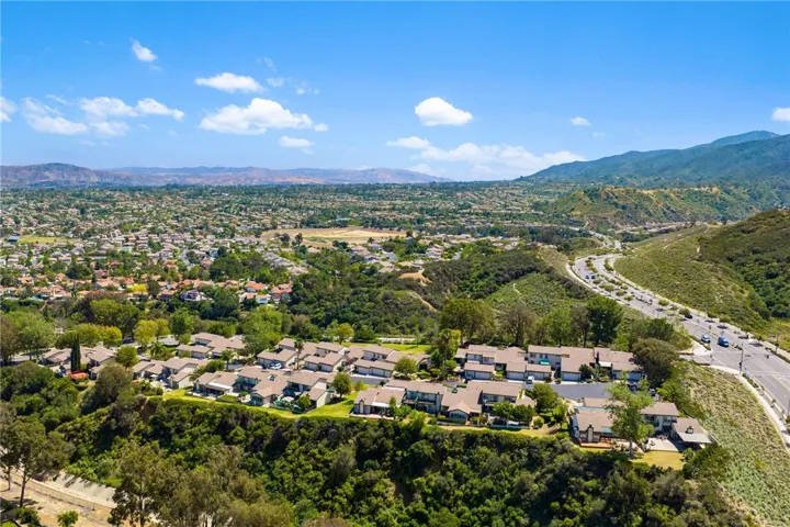 Sweeping aerial view showcases the surrounding neighborhood, rolling hills, and broad valley outlooks.