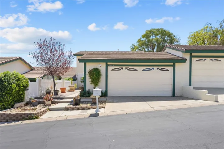 Street-facing view of the garage and entry path presents a tidy exterior with low-maintenance landscaping.