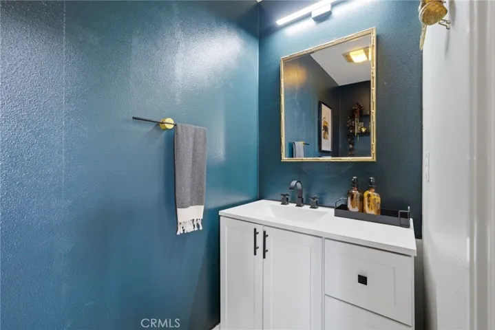 Convenient downstairs half bath with white shaker vanity and matte black finishes.