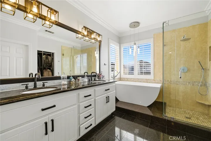 Private en-suite bathroom with dual vanities and freestanding soaking tub.