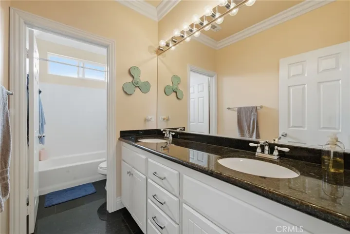 Full hallway bathroom with dual vanities and functional layout.