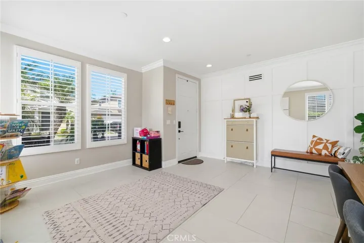 Light-filled front living space with plantation shutters and crown molding.
