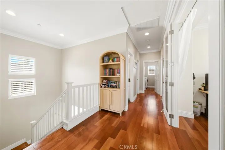 Cherry wood hardwood flooring, crown molding, and recessed lighting throughout.
