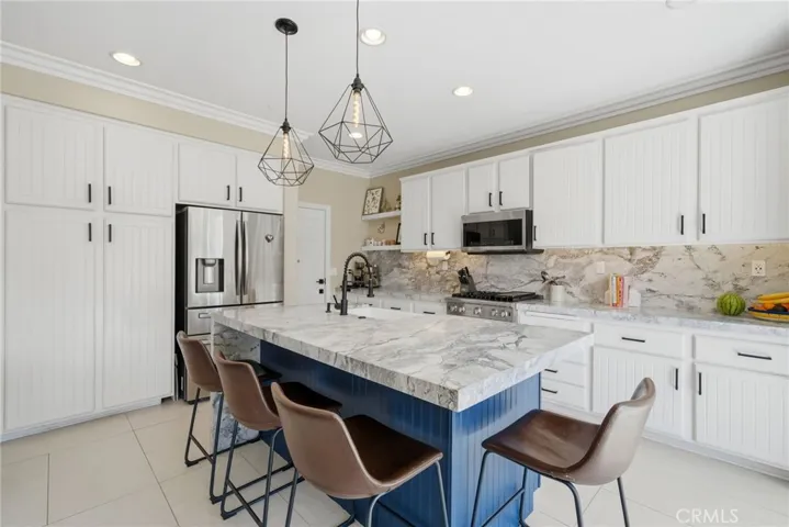 Center island with bar seating, pendant lighting, and added prep space.