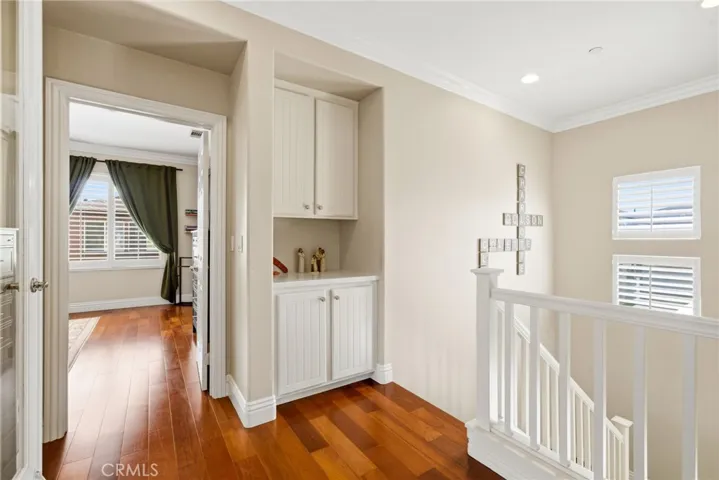 Cherry wood hardwood flooring, crown molding, and recessed lighting throughout.