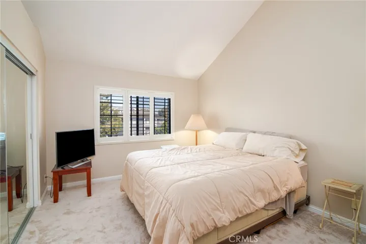 Primary bedroom features vaulted ceiling, mirrored wardrobe doors, plantation shutters and brand new carpet.