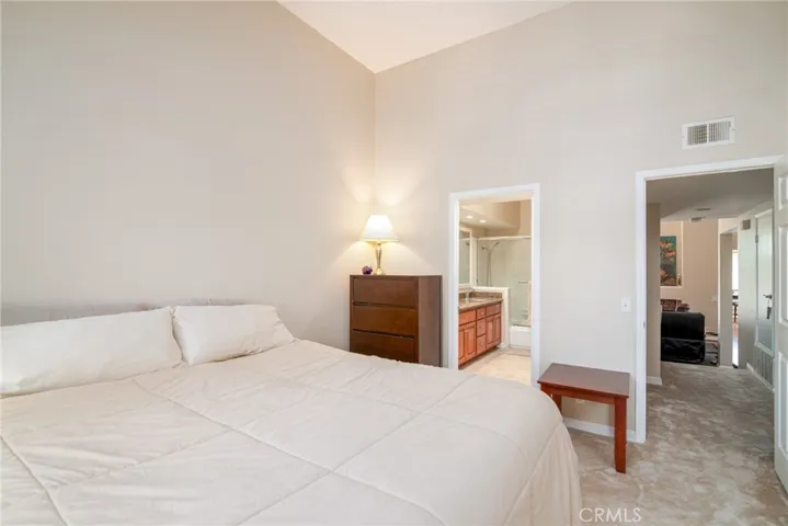 A second view of the primary bedroom towards the ensuite bathroom and entryway.