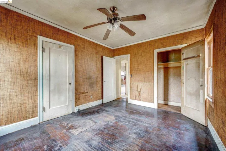 Unfurnished bedroom with wood-type flooring, ceiling fan, a closet, and crown molding