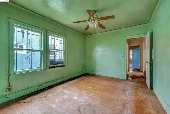 Unfurnished room featuring hardwood / wood-style flooring, ceiling fan, and crown molding