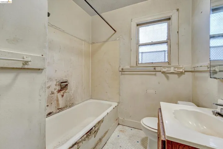 Bathroom featuring vanity, tile patterned flooring, and washtub / shower combination