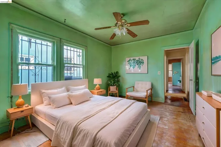 Bedroom with wood-type flooring, a ceiling fan, and crown molding