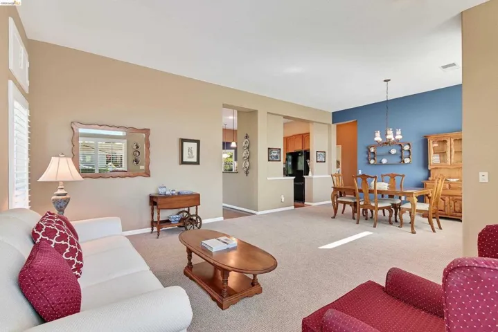 Living area featuring suspended lighting and light carpet