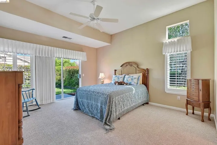 Bedroom featuring access to outside, light colored carpet, and a ceiling fan